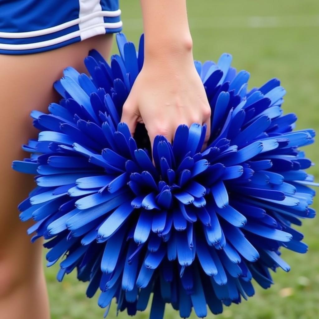 A cheerleader demonstrating the proper grip and hand positioning for holding pom poms.