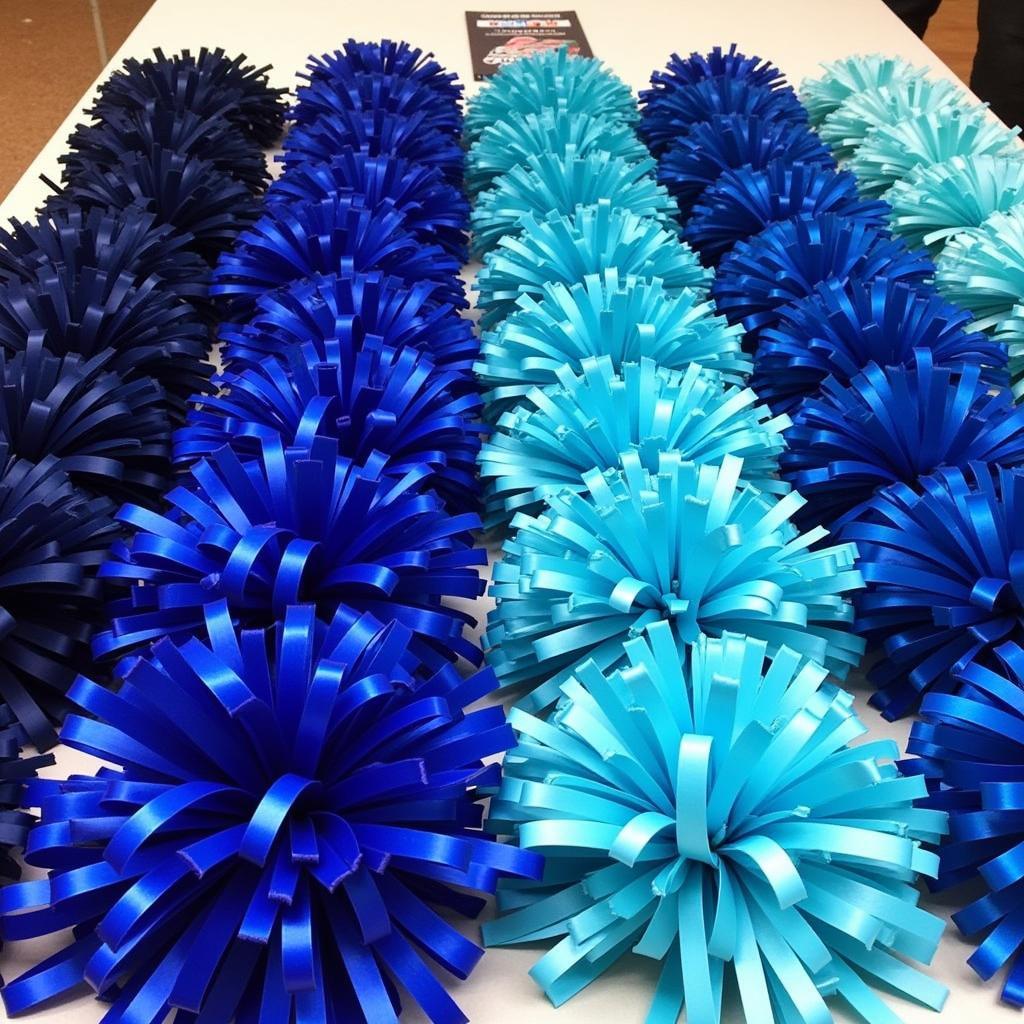 An assortment of cheerleading pom poms in various shades of blue.