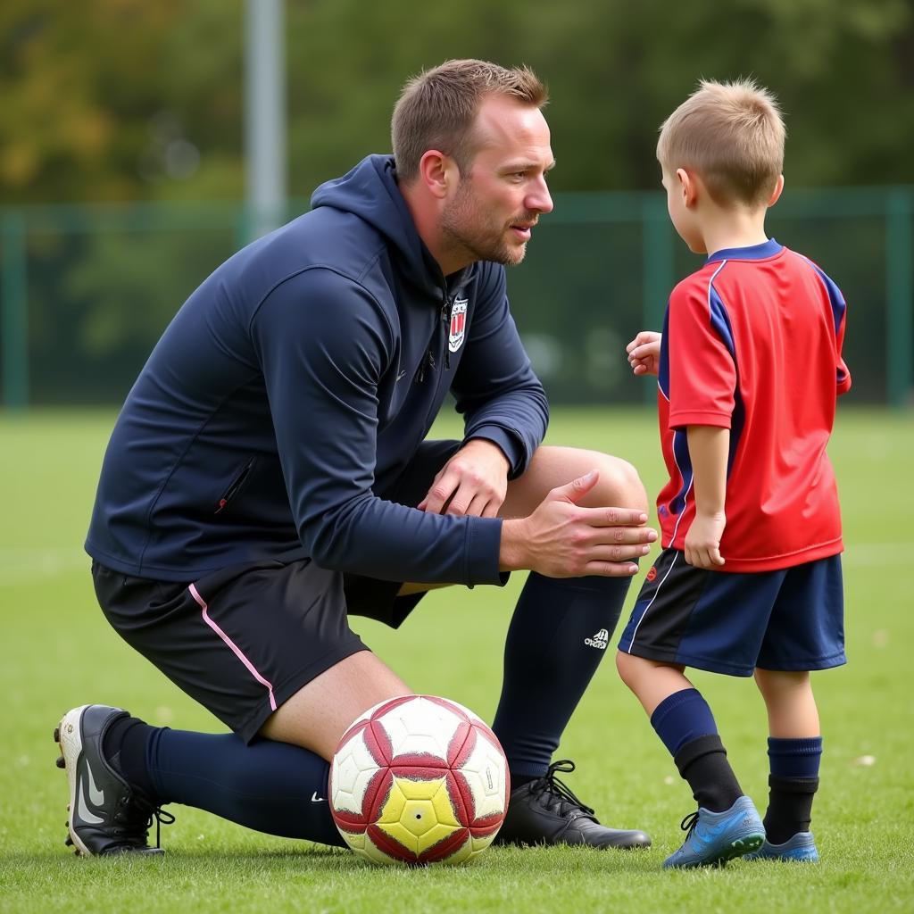 Youth football coach providing guidance to a young player